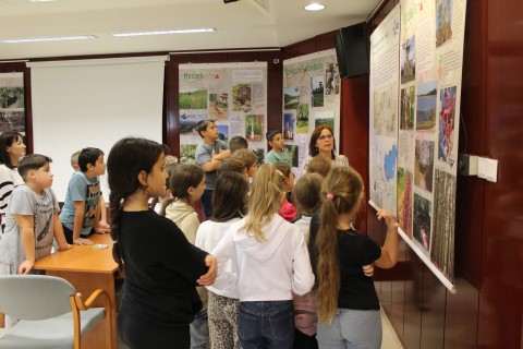 A gyerekek meghallgatják a tárlatvezetést.