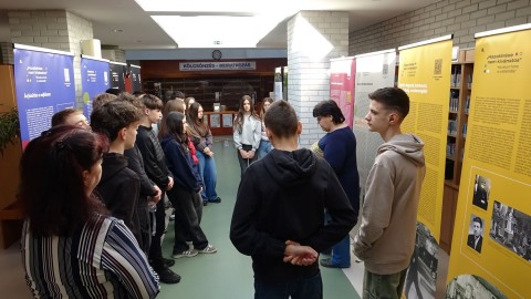 Középiskolai diákok meghallgatják a tárlatvezetést.